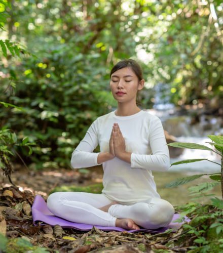 Beautiful girls are playing yoga at the park. Among the natural waterfalls in the forest, exercise concepts